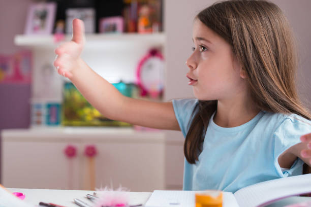 istock Serious school girl explaining she can't concentrate on homework 1309789839