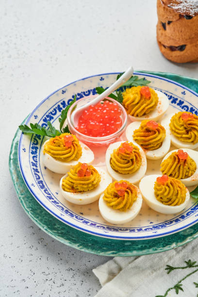istock Stuffed eggs with red caviar and paprika on plate for appetizer easter table, top view, copy space. Traditional dish for Happy Easter holiday. 1309790954