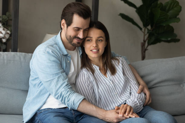 istock Happy loving young couple hugging, relaxing on couch together 1309791006