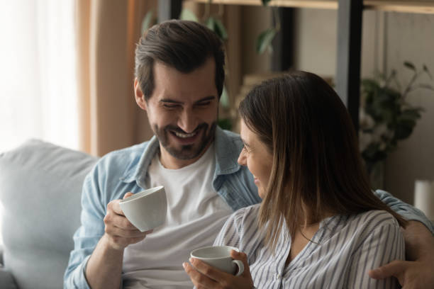 istock Close up happy young couple hugging, holding cups, drinking tea 1309791011
