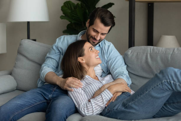 istock Close up happy young couple relaxing on couch together 1309791020