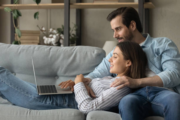 istock Side view smiling woman using laptop, lying on boyfriend laps 1309791021