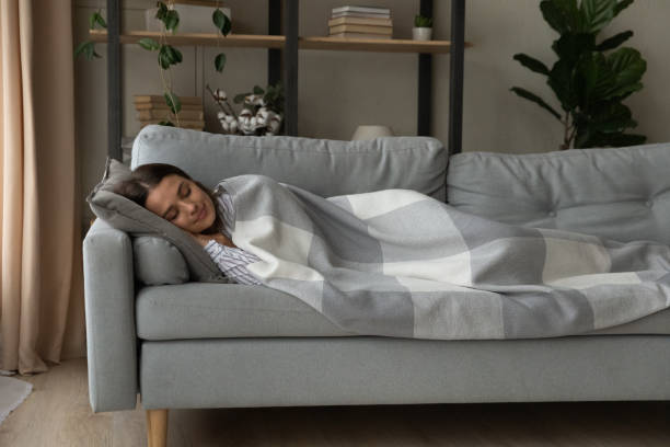 istock Peaceful woman sleeping under warm blanket on cozy couch 1309791032