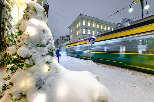 Aleksanterinkatu street during the strong snowstorm. The tram is moving on the street. Helsinki, Finland.