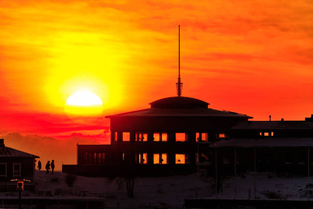 In the foreground the two-storied building in the background an amazing big sun during the sunset.