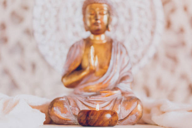 istock Golden white Buddha with a candle in soft and bright ambience 1309792531