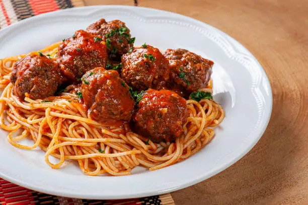 Photo of Meatballs with tomato sauce and pasta. Top view  - Almondegas.