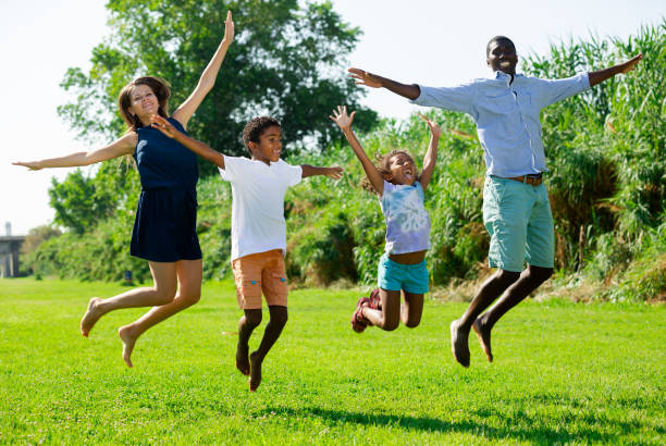 istock Happy kids with parents jumping 1309792809