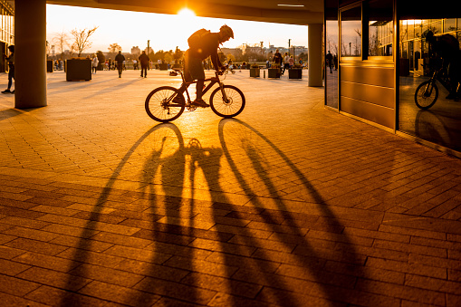 Urban male riding bicycle in the city during the golden hour.