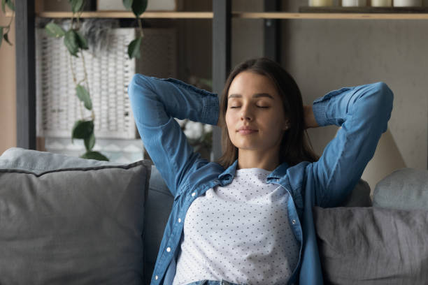 istock Close up peaceful woman with closed eyes relaxing on couch 1309797965