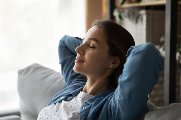 istock Close up calm woman with closed eyes resting on couch 1309797974