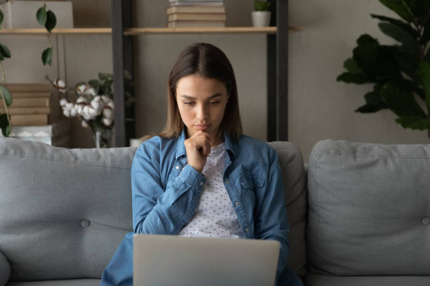 istock Close up thoughtful focused woman looking at laptop screen 1309797988