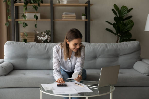 istock Smiling woman using laptop, managing finances, planning budget at home 1309798040