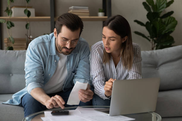 istock Couple calculating domestic bills, planning budget together, using laptop 1309798054