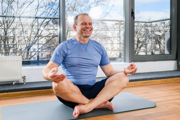 istock Smiling aged man in yoga lotus pose 1309799010