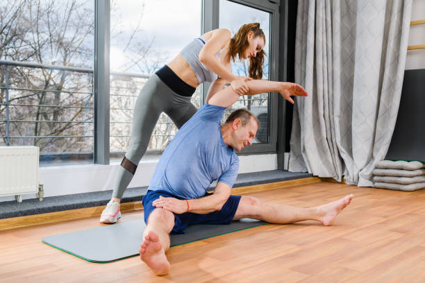 istock Young trainer stretch mature man muscles 1309799105