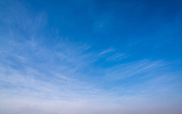 istock background of blue sky with wispy white clouds towards the bottom 1309799533