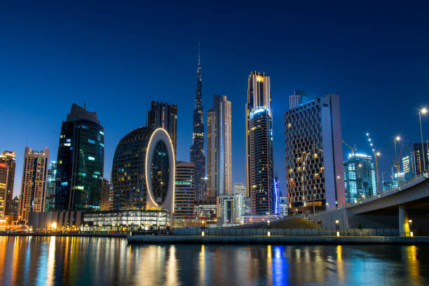 Dubai skyline view from the Marasi marina in city Business bay downtown area in the UAE Dubai modern architecture landmark skyline view from the Marasi marina in city Business bay downtown area in the United Arab Emirates at blue hour at night dubai marina panorama stock pictures, royalty-free photos & images