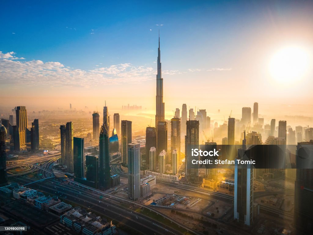 Aerial skyline of downtown Dubai filled with modern skyscrapers in the UAE Aerial skyline of downtown Dubai filled with modern skyscrapers in the United Arab Emirates rising above the main city highway aerial view at sunrise Dubai Stock Photo