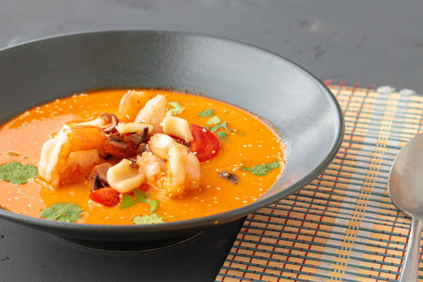istock Tom Yam Thai soup in black bowl on gray table 1309800699