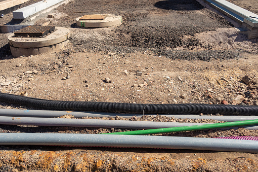 A variety of pipes in front of the preparation work for a new road.