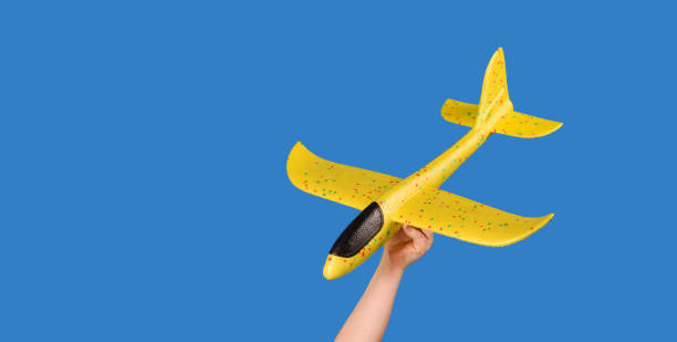 istock Yellow toy plane on a blue background. Traveling concept. 1309804171