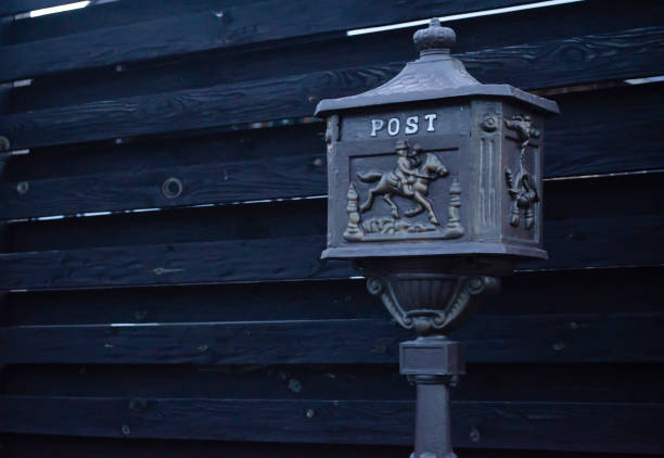 Vintage mailbox. Beautiful old-fashioned mailbox black. Mailbox on the background of a black fence