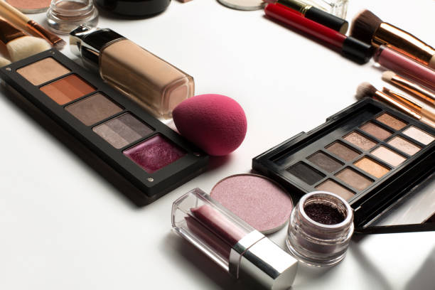 istock Set of highlighter, pink lip gloss and makeup palettes on a white background. Space for text 1309804921