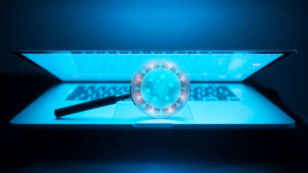 istock Magnifying glass on laptop shows virus infection 1309805243