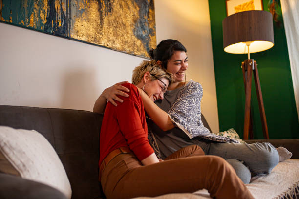 istock Lesbian couple laughing on the sofa 1309806676