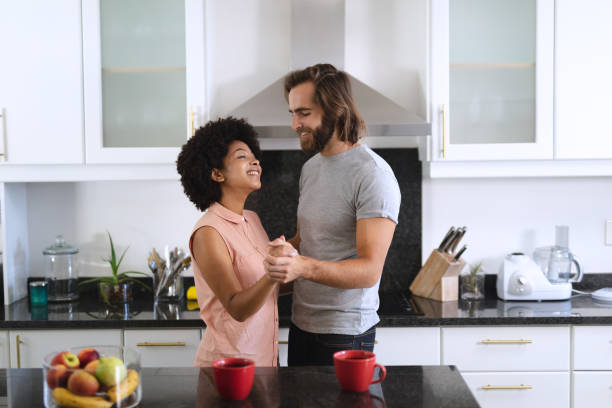 istock Happy diverse couple dancing in kitchen and smiling 1309806947