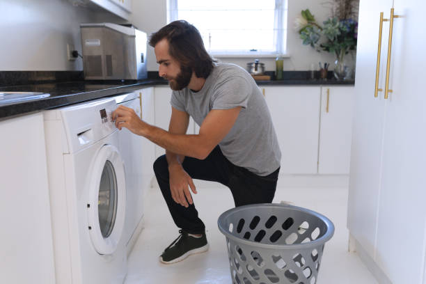 istock Caucasian man wearing gray tshirt and doing laundry 1309807817