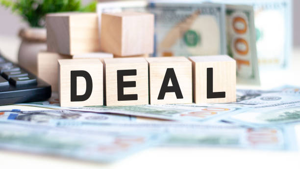 istock wooden blocks with text DEAL and banknotes on table, concept 1309808145
