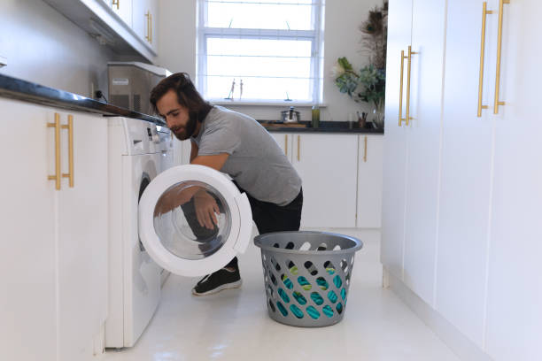 istock Caucasian man wearing gray tshirt and doing laundry 1309809269