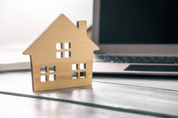 istock wooden house model on computer laptop 1309809333