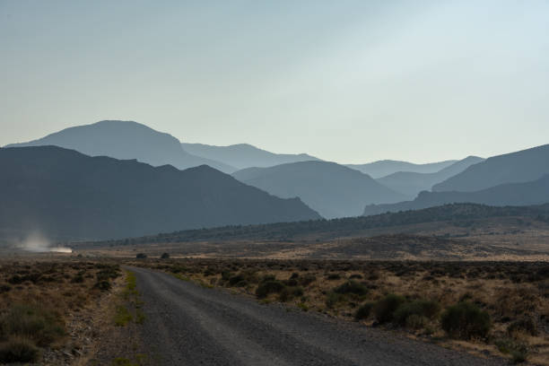 istock Truck Kicks Up Dust On Distant Dirt Road 1309809451