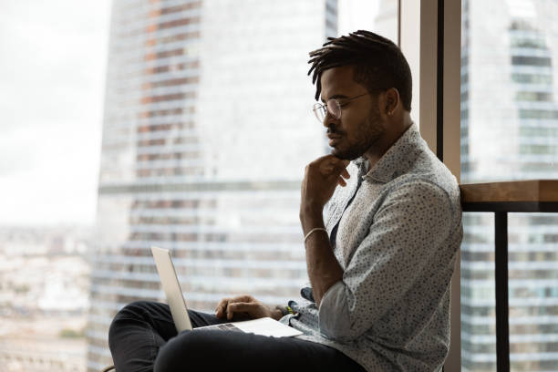 istock Side view thoughtful African American man looking at laptop screen 1309809643