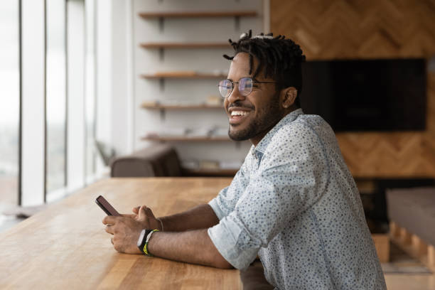 istock Close up smiling African American man distracted from phone 1309810168