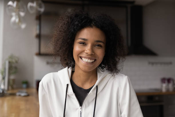hoofd ontsproten portret glimlachende afrikaanse amerikaanse vrouw die videogesprek maakt - gesprek coaching detail stockfoto's en -beelden