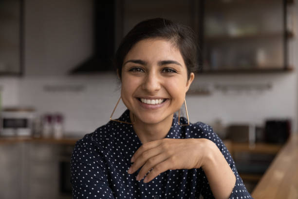 hoofd ontsproten portret glimlachende indische vrouw die videogesprek maakt - gesprek coaching detail stockfoto's en -beelden