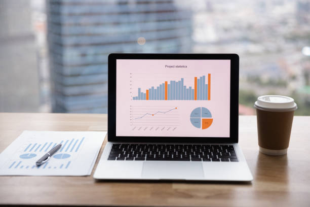 istock Close up office interior, workplace with laptop, financial documents 1309812874