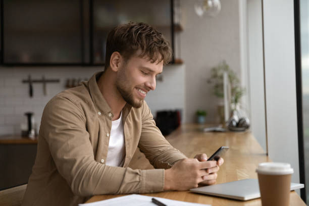 istock Close up smiling man using phone, reading good news 1309812905