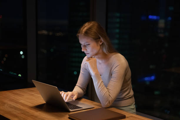 istock Close up thoughtful businesswoman using laptop, working at night 1309812972