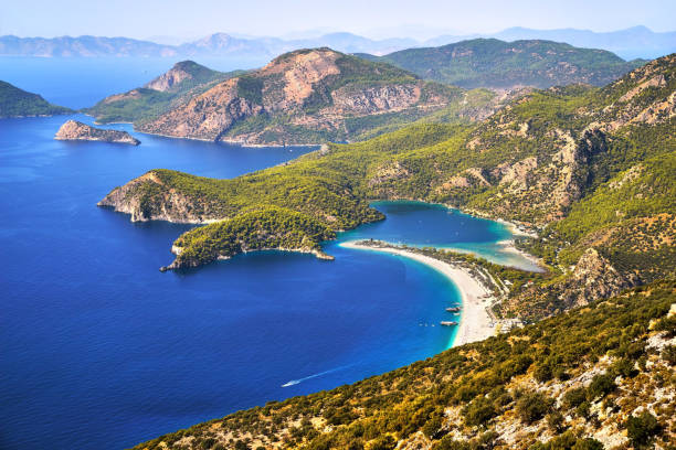 Panoramic aerial view of touristic town, blue sea, beach and lagoon. Oludeniz, Fethiye, Turkey. Panoramic aerial view of touristic town, blue sea, beach and lagoon. Wooded rocky mountains coast sunny day. Oludeniz, Fethiye, Turkey. southern turkey stock pictures, royalty-free photos & images