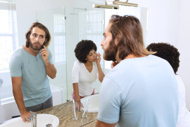 istock Diverse couple standing in bathroom applying face cream 1309815346
