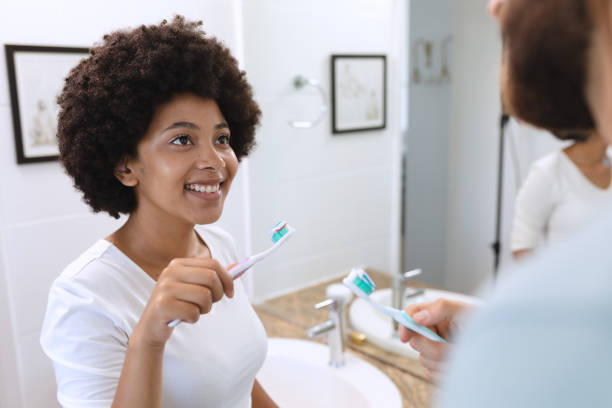 istock Diverse couple standing in bathroom brushing teeth 1309815378