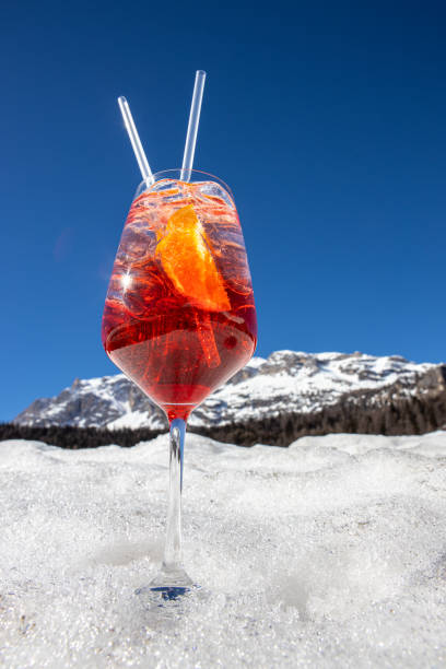 стакан spritz, типичный итальянский аперитивный коктейль, на снегу в кортина д'ампеццо, италия - cortina dampezzo стоковые фото и изображения