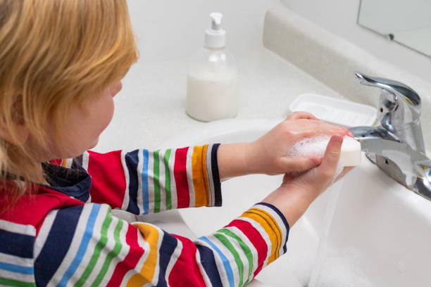 istock Child washing hands with soap in the bathroom 1309818280