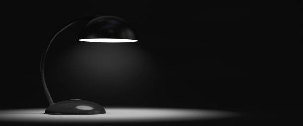 The table lamp is on. A dark room. Copy space.