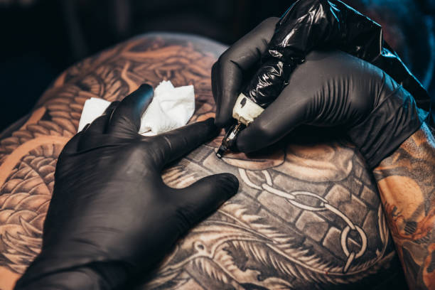 istock Tattoo artist hands holding a machine 1309819384